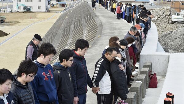 People observe a moment of silence at 2:46 p.m. (0546 GMT), the time when the magnitude 9.0 earthquake struck off Japan's coast in 2011, atop of a seawall at Taro district in Miyako, Iwate prefecture, Japan, March 11, 2016, to mark the fifth-year anniversary of the March 11, 2011 earthquake and tsunami that killed thousands and set off a nuclear crisis. - Sputnik International