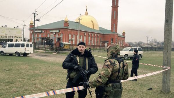 Police officers stand guard in front of a mosque after a blast in Nazran, Russia - Sputnik International