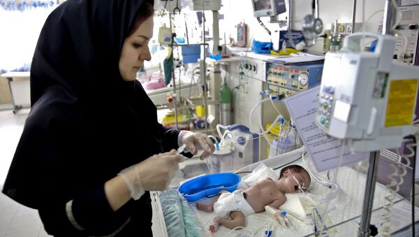 In this Monday, Dec. 30, 2013 photo, a nurse cares for a newborn baby in the Neonatal Intensive Care Unit of the Mofid Children Hospital in Tehran, Iran - Sputnik International