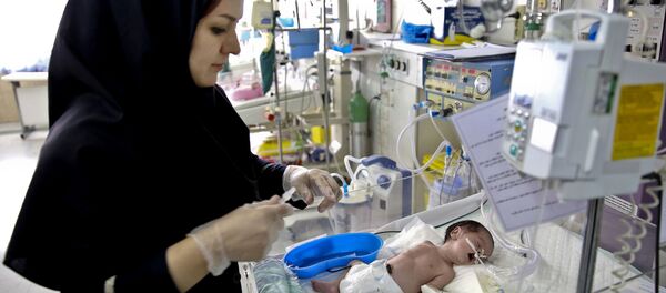 In this Monday, Dec. 30, 2013 photo, a nurse cares for a newborn baby in the Neonatal Intensive Care Unit of the Mofid Children Hospital in Tehran, Iran In this Monday, Dec. 30, 2013 photo, a nurse cares for a newborn baby in the Neonatal Intensive Care Unit of the Mofid Children Hospital in Tehran, Iran - Sputnik International