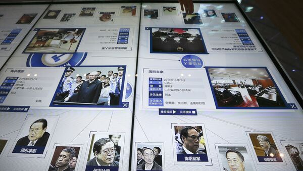 visitor, top, looks at an electronic screen displaying images and convicted corruption charges of China's fallen politicians, Bo Xilai, bottom second right, Zhou Yongkang, bottom left, and other senior officials, at the China Court Museum in Beijing, Tuesday, Jan. 12, 2016 - Sputnik International