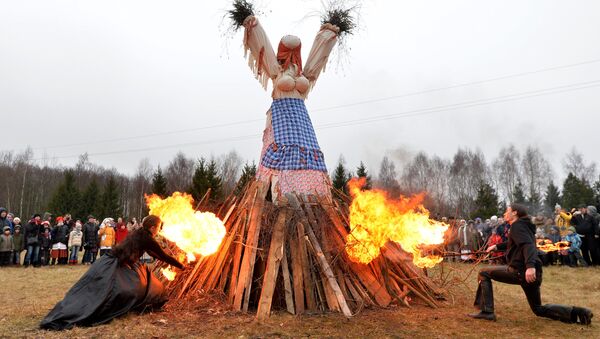 Participants of the folk ensemble burn the scarecrow of the Winter durin the celebration of Maslenitsa on the territory of the Belarussian State Museum of Folk Architecture and Culture in the village of Ozertso outside Minsk - Sputnik International