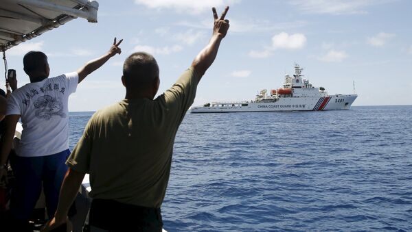 Filipino soldiers gesture at a Chinese Coast Guard vessel on the disputed Second Thomas Shoal, part of the Spratly Islands, in the South China Sea March 29, 2014 - Sputnik International
