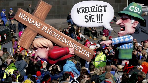 A carnival float with papier-mache caricature mocking German Chancellor Angela Merkel is displayed at a postponed Rosenmontag (Rose Monday) parade, at one location in Duesseldorf, Germany, March 13, 2016. Words read 'Crucify her' 'Humane politics for migrants' - Sputnik International