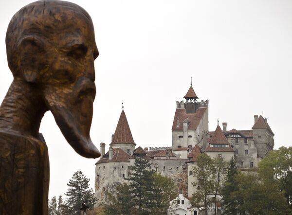 A sculpture commemorating Petru Darascu, a Romanian priest who survived several Communist prisons, by Ovidiu Nicolae Popa is backdropped by the Gothic Bran Castle, better known as Dracula Castle, in Bran, in Romania's central Transylvania region, Saturday, Oct. 8, 2011 - Sputnik International