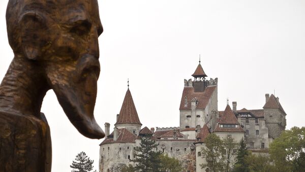 A sculpture commemorating Petru Darascu, a Romanian priest who survived several Communist prisons, by Ovidiu Nicolae Popa is backdropped by the Gothic Bran Castle, better known as Dracula Castle, in Bran, in Romania's central Transylvania region, Saturday, Oct. 8, 2011 - Sputnik International