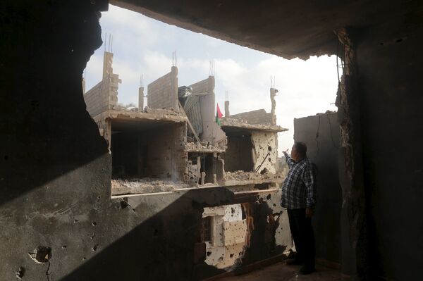 A man stands in his house which was destroyed during clashes between military forces loyal to Libya's eastern government and the Shura Council of Libyan Revolutionaries, an alliance of former anti-Gaddafi rebels who have joined forces with the Islamist group Ansar al-Sharia, are seen in Benghazi, Libya March 12, 2016 A man stands in his house which was destroyed during clashes between military forces loyal to Libya's eastern government and the Shura Council of Libyan Revolutionaries, an alliance of former anti-Gaddafi rebels who have joined forces with the Islamist group Ansar al-Sharia, are seen in Benghazi, Libya March 12, 2016 - Sputnik International