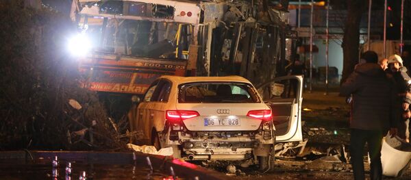 A man stands next to a burnt out bus after a blast in Ankara on March 13, 2016 - Sputnik International