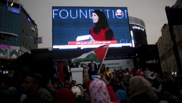 Palestinians watch on a screen in the West Bank city of Ramallah March 13, 2016 as primary school teacher Hanan al-Hroub receives the Million Dollar Teacher award - Sputnik International
