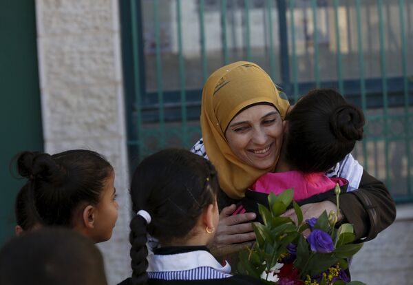 Palestinian teacher Hanan al-Hroub, who is shortlisted to win the Global Teacher Prize, is hugged by a student in the West Bank city of Ramallah February 17, 2016 Palestinian teacher Hanan al-Hroub, who is shortlisted to win the Global Teacher Prize, is hugged by a student in the West Bank city of Ramallah February 17, 2016 - Sputnik International