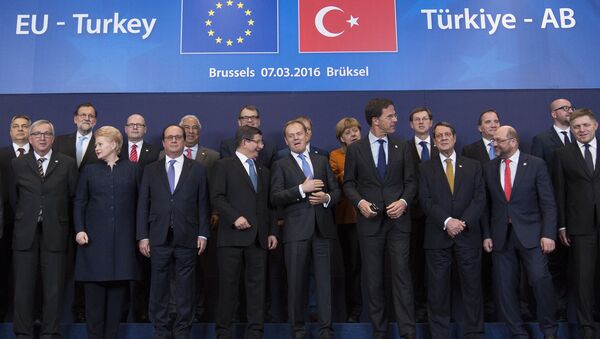 Turkish Prime Minister Ahmet Davutoglu (C) poses with European Union leaders during a EU-Turkey summit in Brussels, as the bloc is looking to Ankara to help it curb the influx of refugees and migrants flowing into Europe, March 7, 2016 - Sputnik International