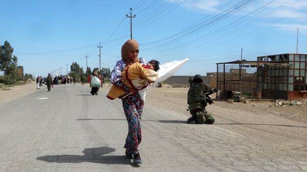 A woman carrying her child flees to safe areas with help from Iraqi security forces, west of Ramadi, March 9, 2016 A woman carrying her child flees to safe areas with help from Iraqi security forces, west of Ramadi, March 9, 2016 - Sputnik International