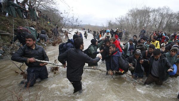Migrants wade across a river near the Greek-Macedonian border, west of the the village of Idomeni, Greece, March 14, 2016 - Sputnik International