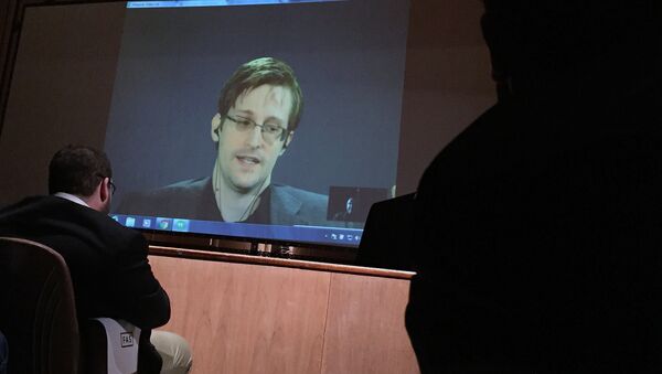 Former National Security Agency contractor Edward Snowden, center speaks via video conference to people in the Johns Hopkins University auditorium, Wednesday, Feb. 17, 2016, in Baltimore - Sputnik International