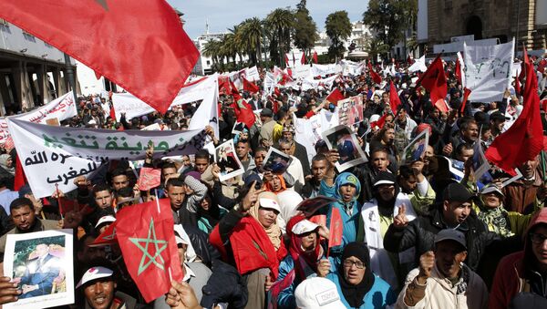 Protesters hold portraits of Morocco's King Mohammed VI and the Moroccan flag as they chant slogans during a rally, in Rabat, Morocco, Sunday, March 13, 2016. Morocco has accused U.N. Secretary-General Ban Ki-moon of abandoning neutrality, objectivity and impartiality during a recent visit to Western Saharan refugee camps in southern Algeria - Sputnik International