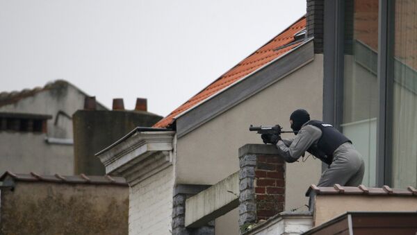 A Belgium police officer secures the area from a rooftop near the scene where shots were fired during a police search of a house in the suburb of Forest near Brussels, Belgium, March 15, 2016 - Sputnik International