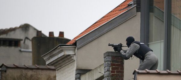 A Belgium police officer secures the area from a rooftop near the scene where shots were fired during a police search of a house in the suburb of Forest near Brussels, Belgium, March 15, 2016 - Sputnik International