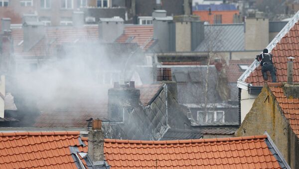 Belgium police officer secures the area from a rooftop at the scene where shots were fired during a police search of a house in the suburb of Forest near Brussels, Belgium, March 15, 2016 - Sputnik International