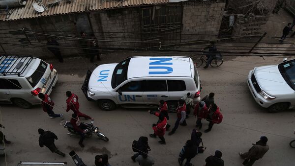 UN vehicles escorting a Red Crescent convoy carrying humanitarian aid arrive in Kafr Batna, in the rebel-held Eastern Ghouta area, on the outskirts of the capital Damascus on February 23, 2016 during an operation in cooperation with the UN to deliver aid to thousands of besieged Syrians - Sputnik International