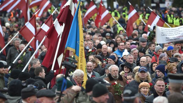Veterans of the Latvian Legion, a force that was commanded by the German Nazi Waffen SS during WWII, and their sympathizers carry flowers as they walk to the Monument of Freedom in Riga, Latvia on March 16, 2016 - Sputnik International