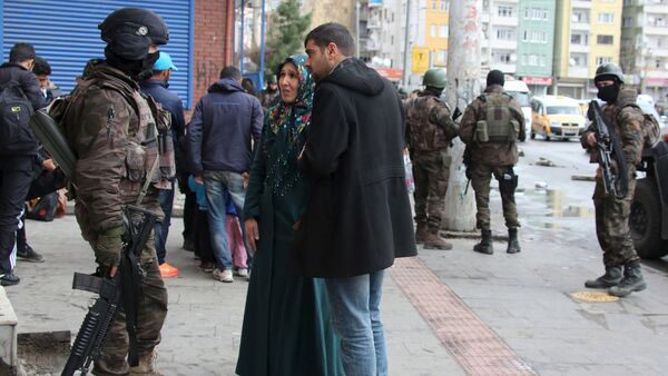 Residents talk to a member of Turkish police special forces as they flee after clashes between security forces and Kurdish militants from Baglar district, which is partially under curfew, in the Kurdish-dominated southeastern city of Diyarbakir, Turkey March 15, 2016 - Sputnik International
