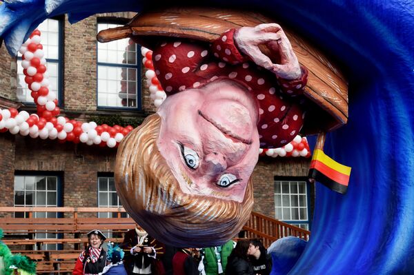 A carnival float depicting German Chancellor Angela Merkel in a small boat on a wave. - Sputnik International
