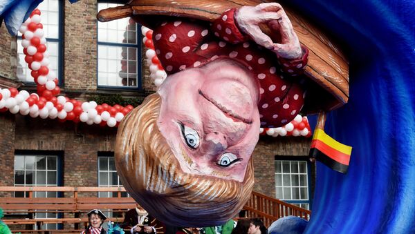 A carnival float depicting German Chancellor Angela Merkel in a small boat on a wave. - Sputnik International