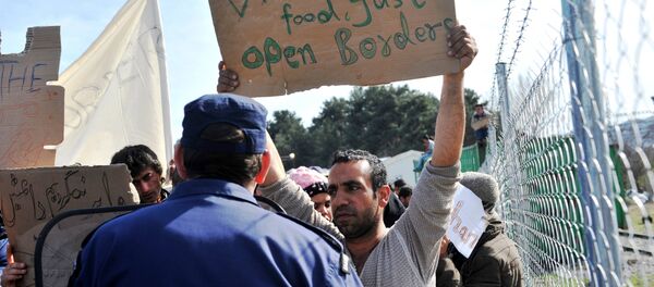 Refugees from Afghanistan protest against the closure of the Greek-Macedonian border near the village of Idomeni, northern Greece, on February 22, 2016. - Sputnik International