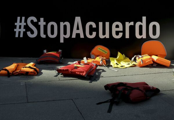 Life vests lie in front of a banner reading Stop the Deal during a protest against the EU-Turkey migrant deal in front of the Spanish foreign ministry in Madrid, Spain, March 16, 2016. Life vests lie in front of a banner reading Stop the Deal during a protest against the EU-Turkey migrant deal in front of the Spanish foreign ministry in Madrid, Spain, March 16, 2016. - Sputnik International