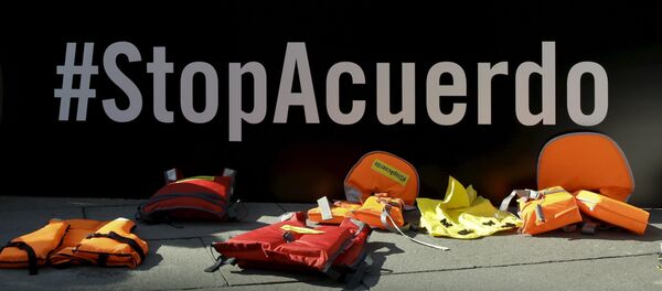 Life vests lie in front of a banner reading Stop the Deal during a protest against the EU-Turkey migrant deal in front of the Spanish foreign ministry in Madrid, Spain, March 16, 2016. - Sputnik International