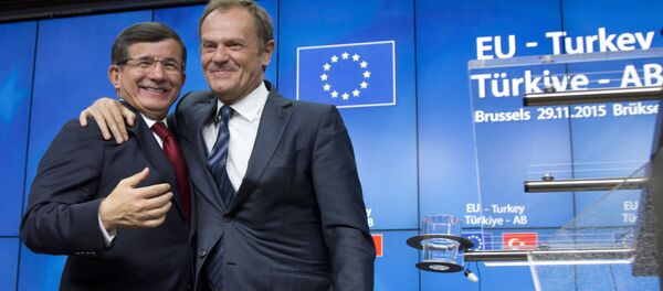 European Council President Donald Tusk, right, puts his arm on the shoulder of Turkish Prime Minister Ahmet Davutoglu after a media conference at an EU-Turkey summit in Brussels on Sunday, Nov. 29, 2015. - Sputnik International