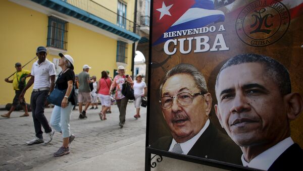 Tourists pass by images of U.S. President Barack Obama and Cuban President Raul Castro in a banner that reads Welcome to Cuba at the entrance of a restaurant in downtown Havana, March 17, 2016. - Sputnik International