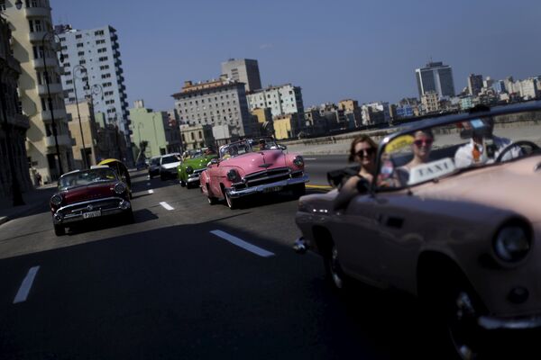Tourists ride in a vintage car at the 'Malecon' seafront in Havana, March 16, 2016. Tourists ride in a vintage car at the 'Malecon' seafront in Havana, March 16, 2016. - Sputnik International