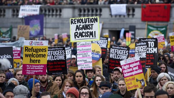 Demonstrators hold banners in support of refugees as they march through central London on March 19, 2016. - Sputnik International