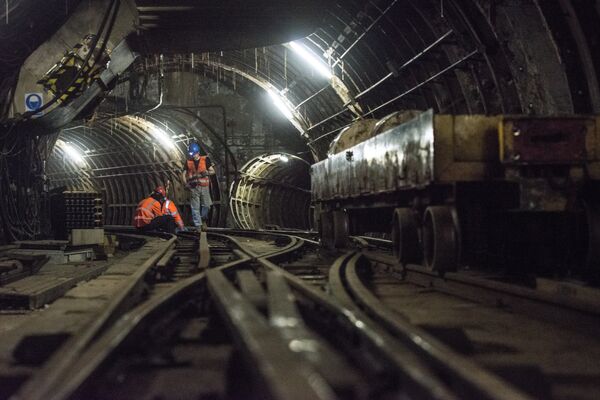 Workers sit on the underground tracks of the Mail Rail, the old rail system that transported mail between sorting offices, as work starts to turn it into a heritage attraction at the new Postal Museum in London Workers sit on the underground tracks of the Mail Rail, the old rail system that transported mail between sorting offices, as work starts to turn it into a heritage attraction at the new Postal Museum in London - Sputnik International
