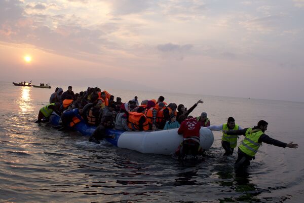 Volunteers help migrants and refugees on a dingy as they arrive at the shore of the northeastern Greek island of Lesbos, after crossing the Aegean sea from Turkey on Sunday, March 20, 2016 Volunteers help migrants and refugees on a dingy as they arrive at the shore of the northeastern Greek island of Lesbos, after crossing the Aegean sea from Turkey on Sunday, March 20, 2016 - Sputnik International