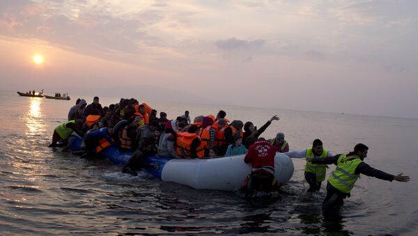 Volunteers help migrants and refugees on a dingy as they arrive at the shore of the northeastern Greek island of Lesbos, after crossing the Aegean sea from Turkey on Sunday, March 20, 2016 - Sputnik International