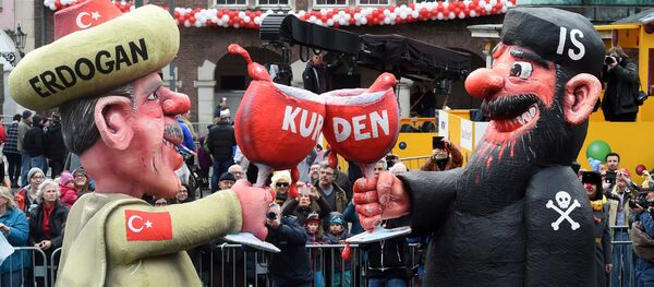 A carnival float depicting Turkish President Recep Tayyip Erdogan (L) clinking his glass with a fighter of the Islamic State (IS) stands in front of the city hall in Duesseldorf, western Germany, after the Rose Monday (Rosenmontag) street parade has been cancelled on February 8, 2016 A carnival float depicting Turkish President Recep Tayyip Erdogan (L) clinking his glass with a fighter of the Islamic State (IS) stands in front of the city hall in Duesseldorf, western Germany, after the Rose Monday (Rosenmontag) street parade has been cancelled on February 8, 2016 - Sputnik International
