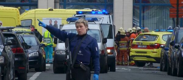 A police woman gestures in front of ambulances at the scene of a blast outside a metro station in Brussels, in this still image taken from video on March 22, 2016 - Sputnik International
