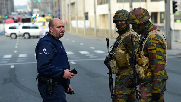 Policemen and soldier stand guard at the entrance of a security perimeter set near Maalbeek metro station, on March 22, 2016 in Brussels, after a blast at this station near the EU institutions caused deaths and injuries - Sputnik International