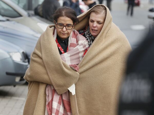 People wrapped in blankets leave the scene of explosions at Zaventem airport near Brussels, Belgium, March 22, 2016. - Sputnik International