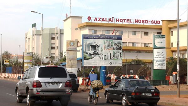 Cars drive past the Azalai Nord-Sud hotel, the site of Monday night's attack in Bamako, Mali, March 22, 2016. - Sputnik International