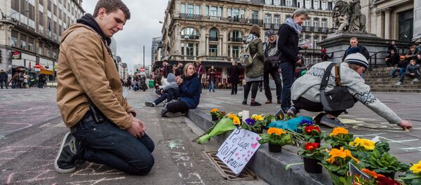 A man looks at flowers and messages outside the stock exchange in Brussels on Tuesday, March 22, 2016 - Sputnik International