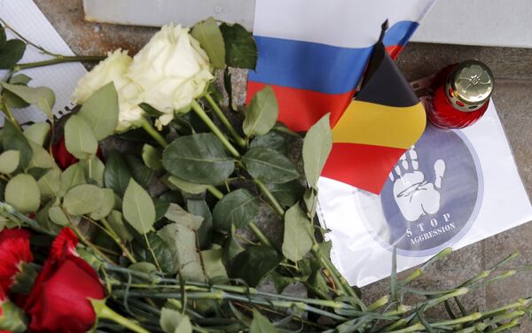 Flowers and a candle for the victims of Brussels attacks are placed in front of the Belgian embassy in Moscow, Russia, March 22, 2016 - Sputnik International