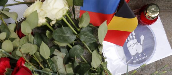 Flowers and a candle for the victims of Brussels attacks are placed in front of the Belgian embassy in Moscow, Russia, March 22, 2016 - Sputnik International