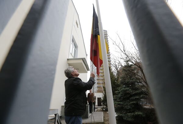 An embassy worker moves the Belgian flag to half mast in tribute to victims of the Brussels attacks, at the Belgian embassy in Moscow, Russia, March 22, 2016 - Sputnik International