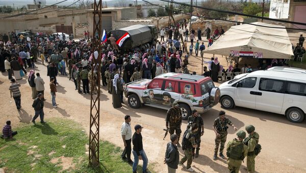 People gather around a Russian military truck to receive a food aid in Maarzaf, about 15 kilometers west of Hama, Syria, Wednesday, March 2, 2016 - Sputnik International