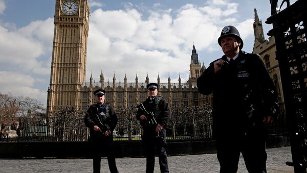 Armed British police officers stand on duty in front of the Elzabeth Tower, better known as Big Ben, outside the vehicle entrance to the Houses of Parliament in central London on March 22, 2016. - Sputnik International