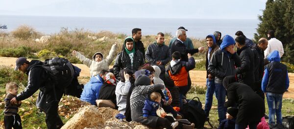 Refugees wait on a roadside after Turkish police prevented them from sailing off to the Greek island of Farmakonisi by dinghies, near a beach in the western Turkish coastal town of Didim, Turkey, March 9, 2016 - Sputnik International