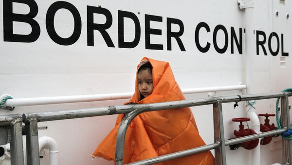 A refugee girl covered with a blanket and rescued at open sea prepares to disembark a Frontex patrol vessel at the port of Mytilene on the Lesbos island, Greece March 22, 2016. - Sputnik International